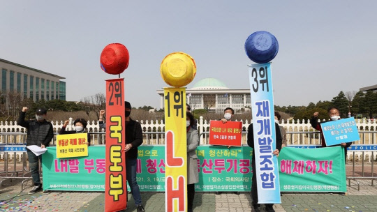 LH개혁국민운동본부, 전국철거민협의회중앙회 등 관계자들이 지난 19일 국회 앞에서 열린 LH 직원 부동산투기 규탄 및 부동산 적폐 청산 촉구 기자회견에서 부동산 적폐 3적 발표 퍼포먼스를 하고 있다. <연합뉴스>